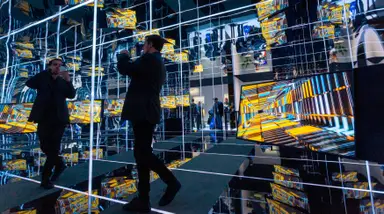 Man taking a picture in a hall of mirrors at CES