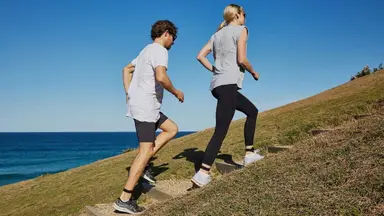 Two walkers climbing a hill wearing Evolve Mvmt step trackers.