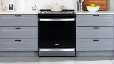 The Whirlpool WEE745H0LZ Electric Range in a modern kitchen between two sets of drawers.