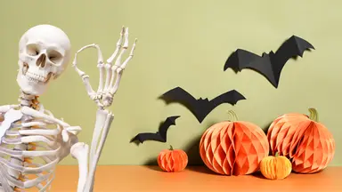 A skeleton gives the A-OK sign to some Halloween decor