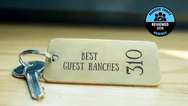 A brass hotel key with a room number on a table