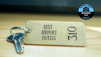 A brass hotel key with a room number on a table