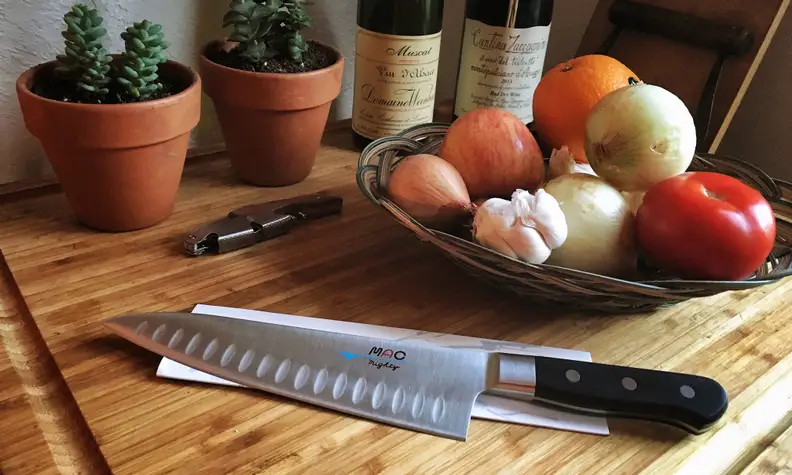 A knife sitting on a table next to some fruit.