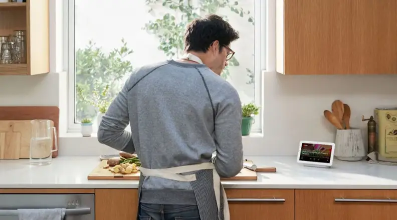 Man in kitchen with Google Nest Hub
