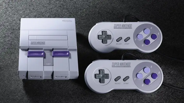 SNES console next to two controllers on grey textured background