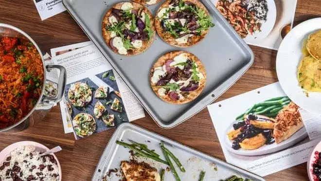 Cooked Home Chef meals surrounded by different recipe cards.
