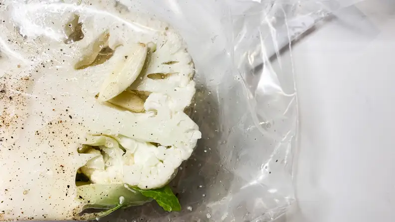 An illustration of half of a head of cauliflower packaged in a sous vide bag pre-cooking.