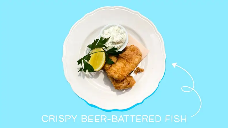 A person places pieces of just-fried fish onto a wire cooling rack.