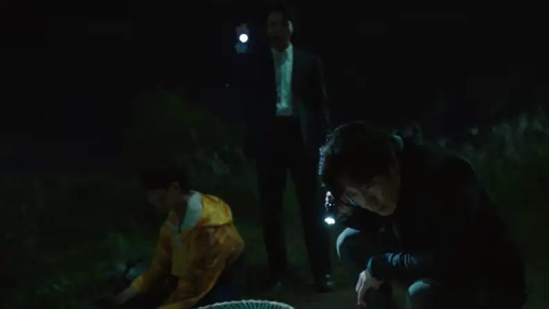 Men holding flashlight after discovering something shocking buried underground.