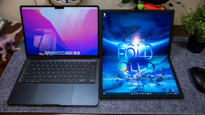 Touchscreen surface of the Zenbook Fold 17 OLED next to  Apple MacBook Pro 16 M1 Max.