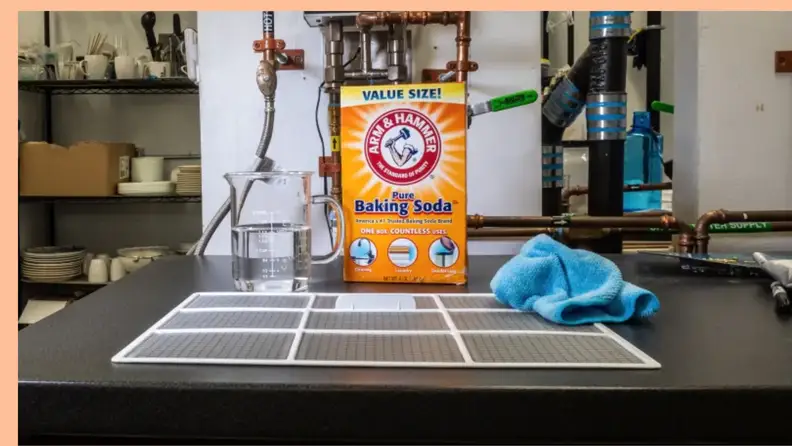 A box of baking soda sits near the removed A/C filter.