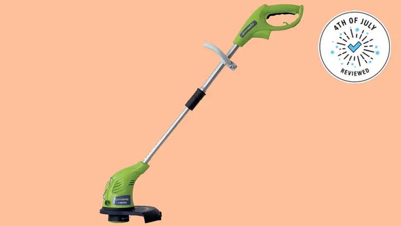 The Greenworks electric trimmer, floating in a peach void.