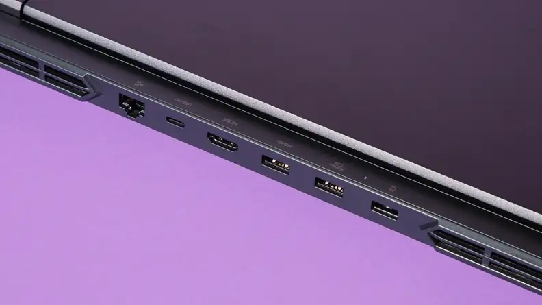 Close-up side view of the Lenovo Legion Pro 5i Gen 8 gaming laptop in black showcasing the USB-C ports, USB-A ports and HDMI ports in front of purple background.