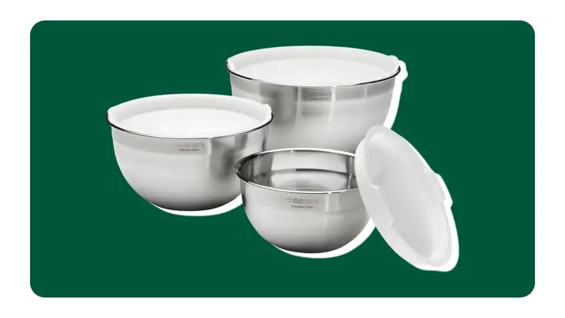 Three stainless steel mixing bowls on a green background