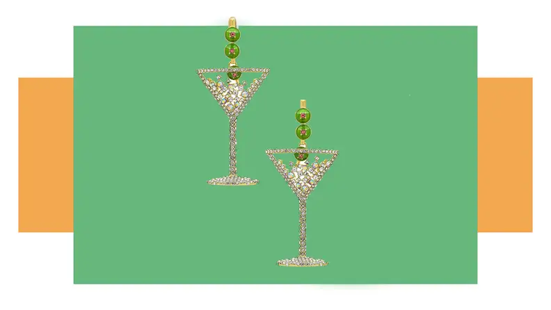 A pair of rhinestone earrings that look like martini glasses with bows on them.