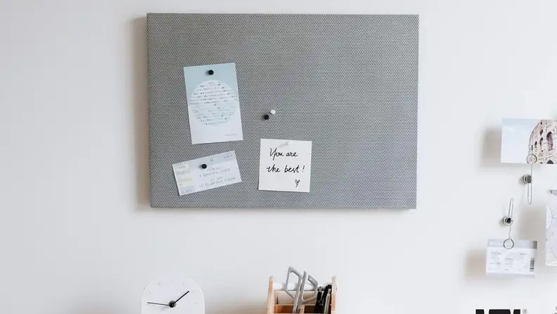 Magnetic board on a wall with paper attached