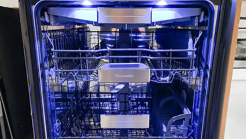 A shot of the interior of the Thermador DWHD770WFM dishwasher, awash in sapphire blue light.