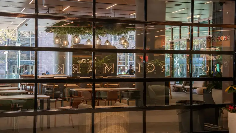 Interior seating area of Monarch Market seen through storefront windows with "Monarch" signage
