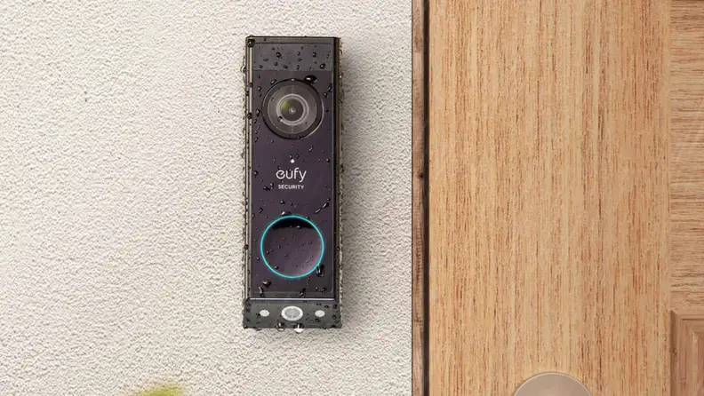 A video doorbell mounted to a wall next to a front door