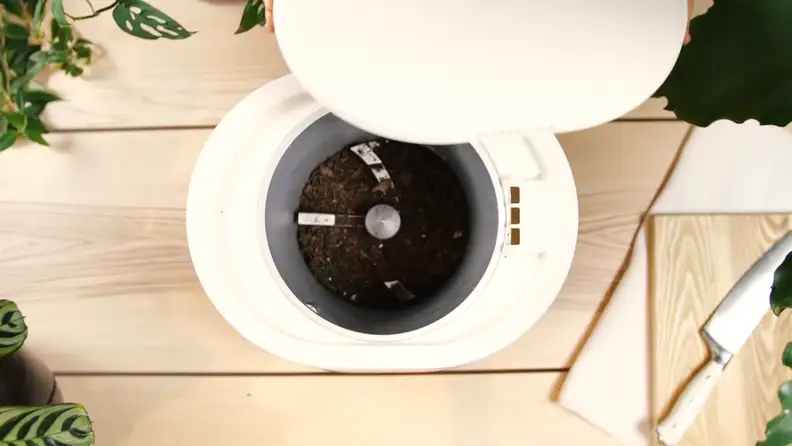 A Lomi composter filled with soil seen from above.