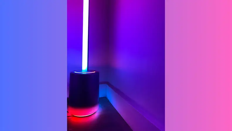 Smart corner floor lamp displaying vibrant blue, purple, and pink gradient effects against a wall, highlighting customizable ambient lighting.