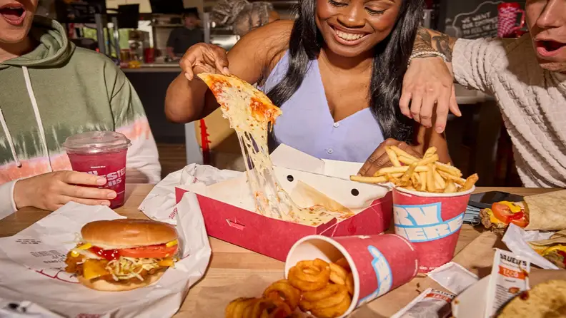 Friends sharing pizza, fries, and sandwiches at Sheetz