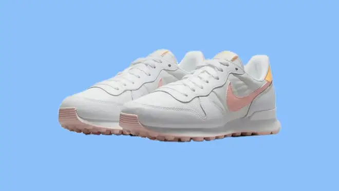 A white pair of Nike shoes on a blue background.