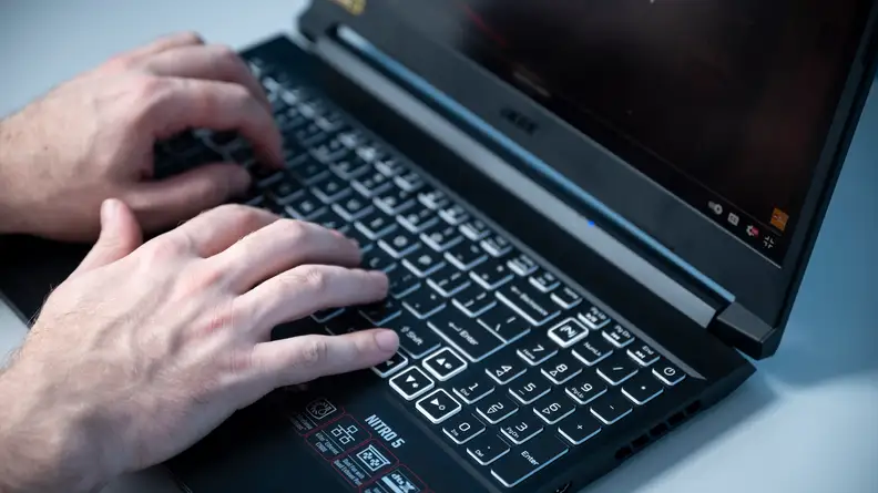 Person types on laptop keyboard