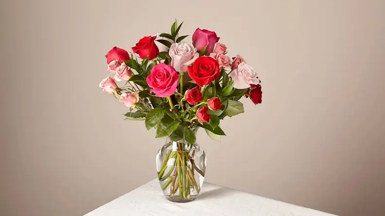 These roses in a glass vase on a table could be one of the best best birthday gifts for Aries season.
