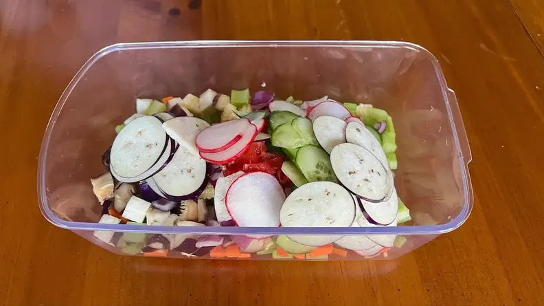 Assorted sliced vegetables within the clear container part of the Fullstar Vegetable Chopper.