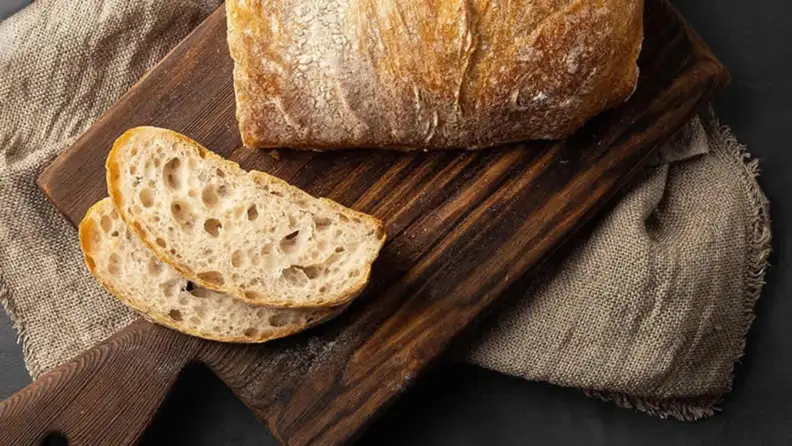 A loaf of bread with two slices cut, showing the airy interior