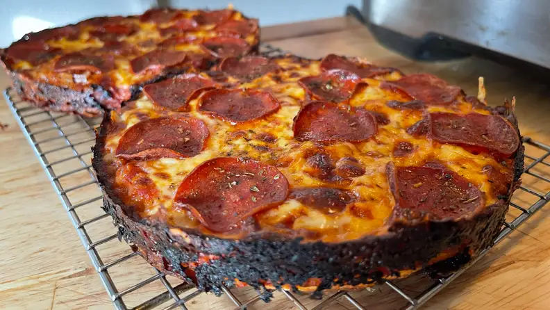 Two pan pizzas on a cooling rack.