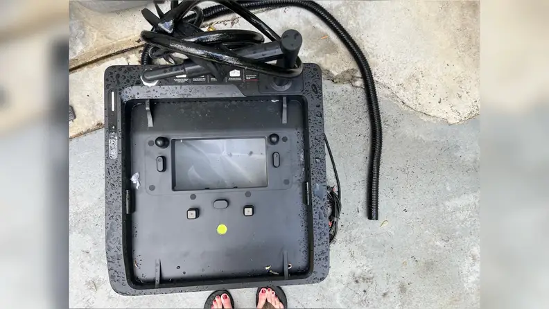 Black Beatbot Aquasense X Robot Pool Cleaner sitting on concrete.