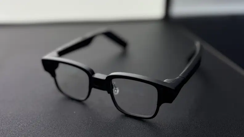 Techno's AI glasses sit on a black table, alone.