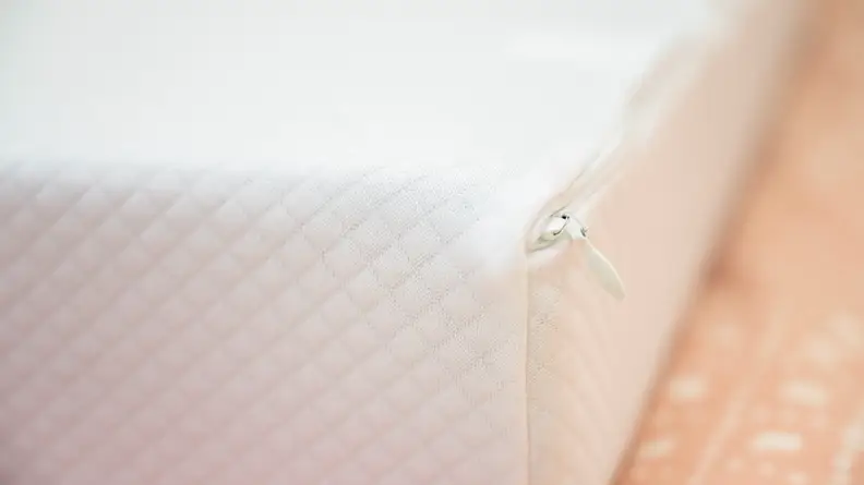 a close up of the the pillow cube on a bed with an orange bed spread