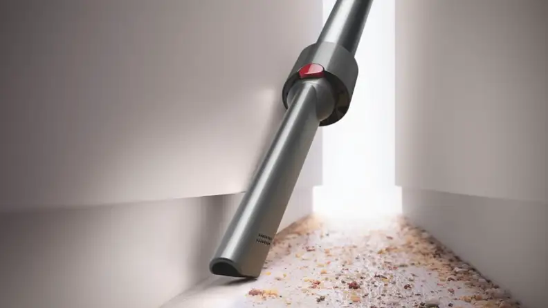 Crevice tool of Dyson V8 Cordless Vacuum cleaning up crumbs off the floor.