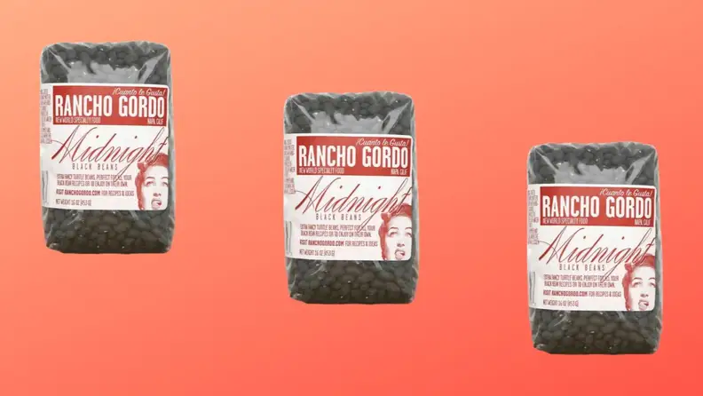 Three packages of black beans arranged in a diagonal row on a red background.