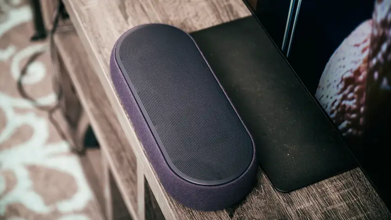 The LG Eclair QP5 sitting in front of a TV's stand