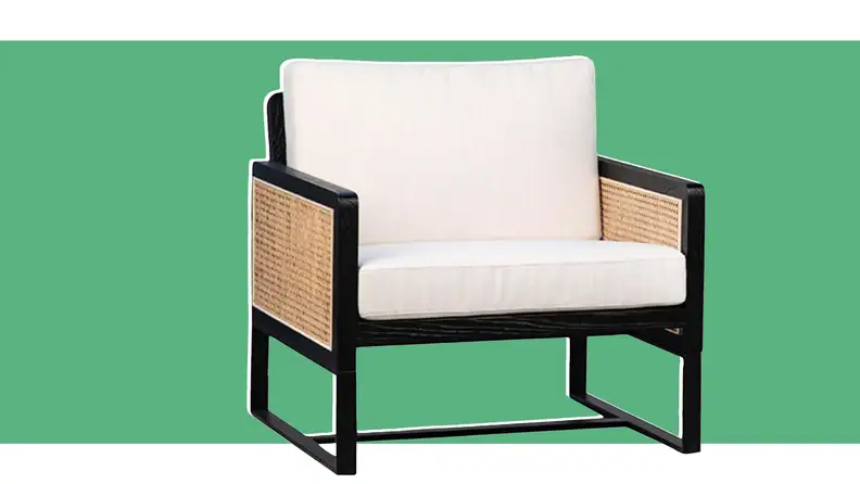 An armchair in front of a green background.
