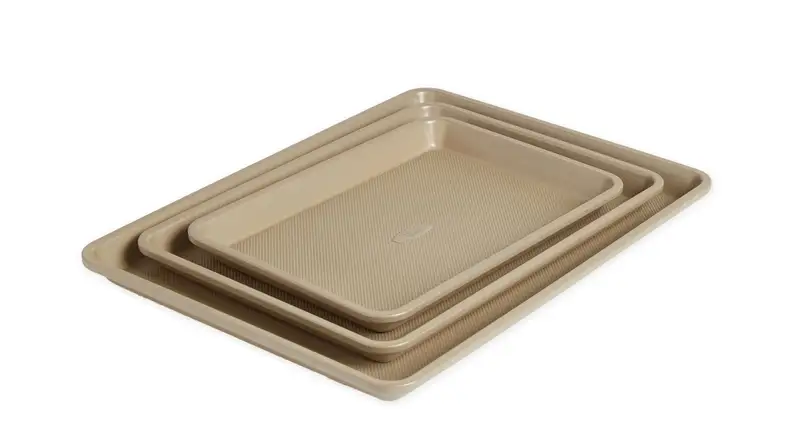 A set of three textured light gold sheet pans.