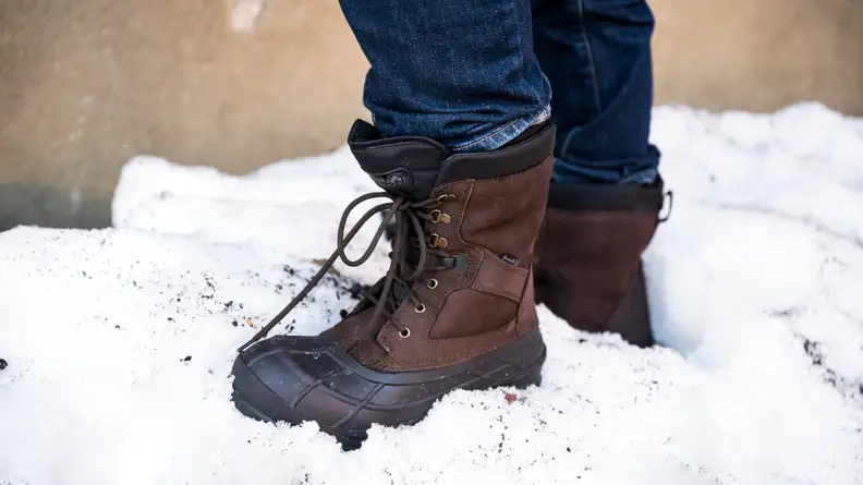 A man wears a pair of Kamik NationPlus Boots in the snow.