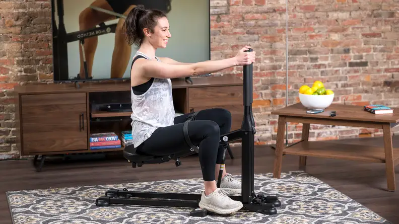 Woman in a squat position on the DB Method machine.