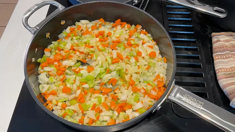 Chopped vegetables being cooked inside a Joesph Joseph pan.