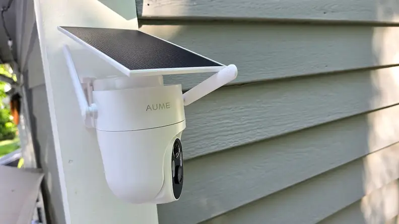 Elysoo 4K Wifi Solar Camera mounted on grey house and showing solar panel above it.