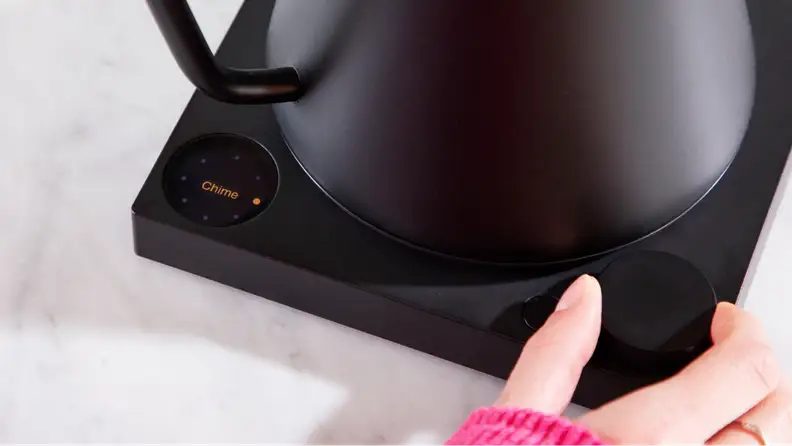 A hand pushing onto the push-dial setting on the Fellow Stagg EKG Pro.