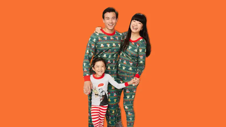 A father, mother, and son wearing Hanna Andersson Star Wars Grogu holiday matching family pajamas.
