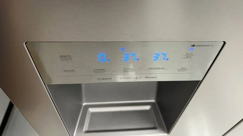 A close-up of the control panel above the Hisense HRM260N6TSE French-door refrigerator's through-the-door dispenser.