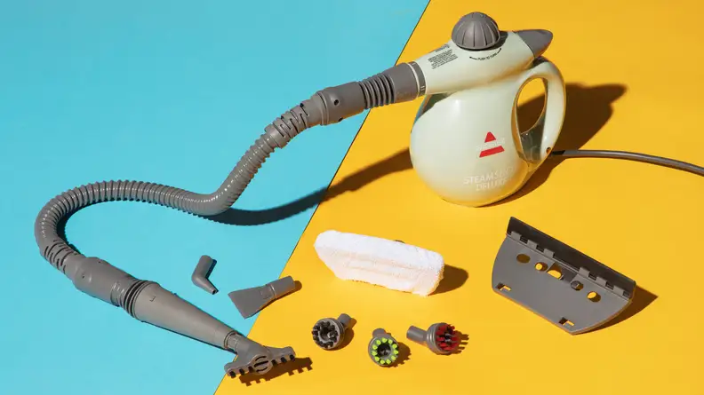 The Bissell Steam Shot Deluxe surrounded by its attachments against a blue and yellow background.