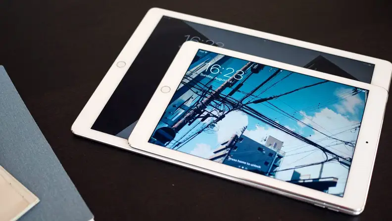 Two iPads of different sizes lay on a table.