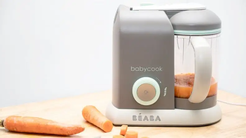Carrots are blended into baby food with the use of a tabletop machine.